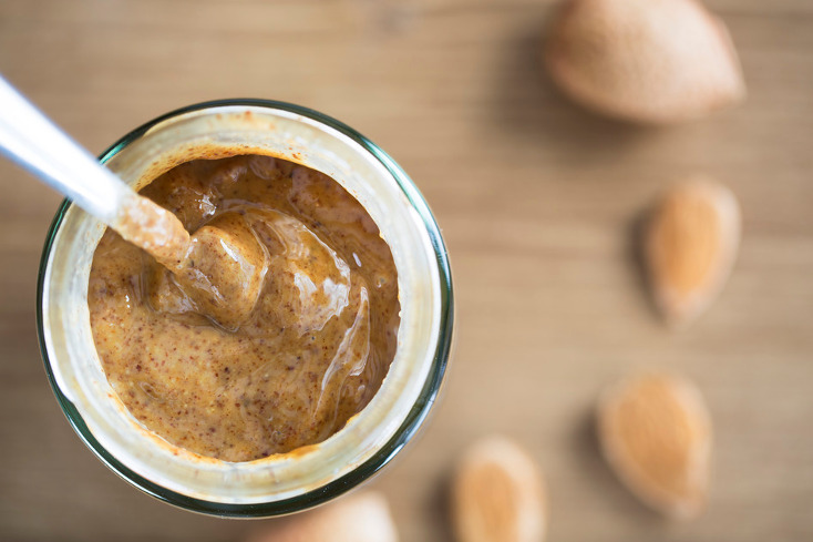 Almond Butter in jar with spoon, from directly above